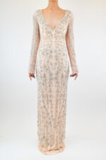 Vestido corte sirena de tela traslucida con pedrería plateada y manga larga