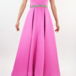 Vestido strapless rosa fuchsia, con escote de corazón y cinto de pedrería y moño