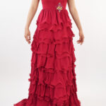 Vestido strapless rojo con falda de olanes y prendedor de brillos en costado